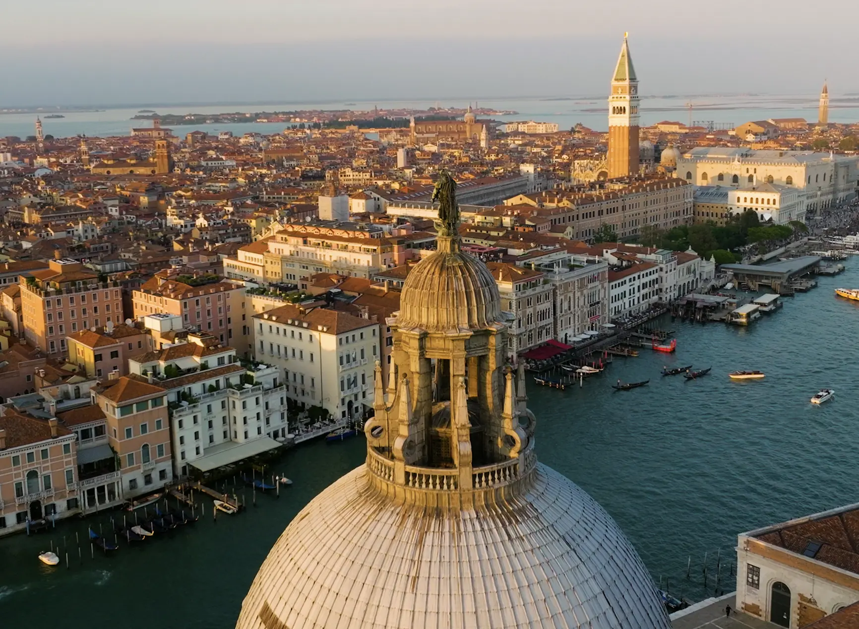 Aerial view of Venice rooftops and church dome at sunset