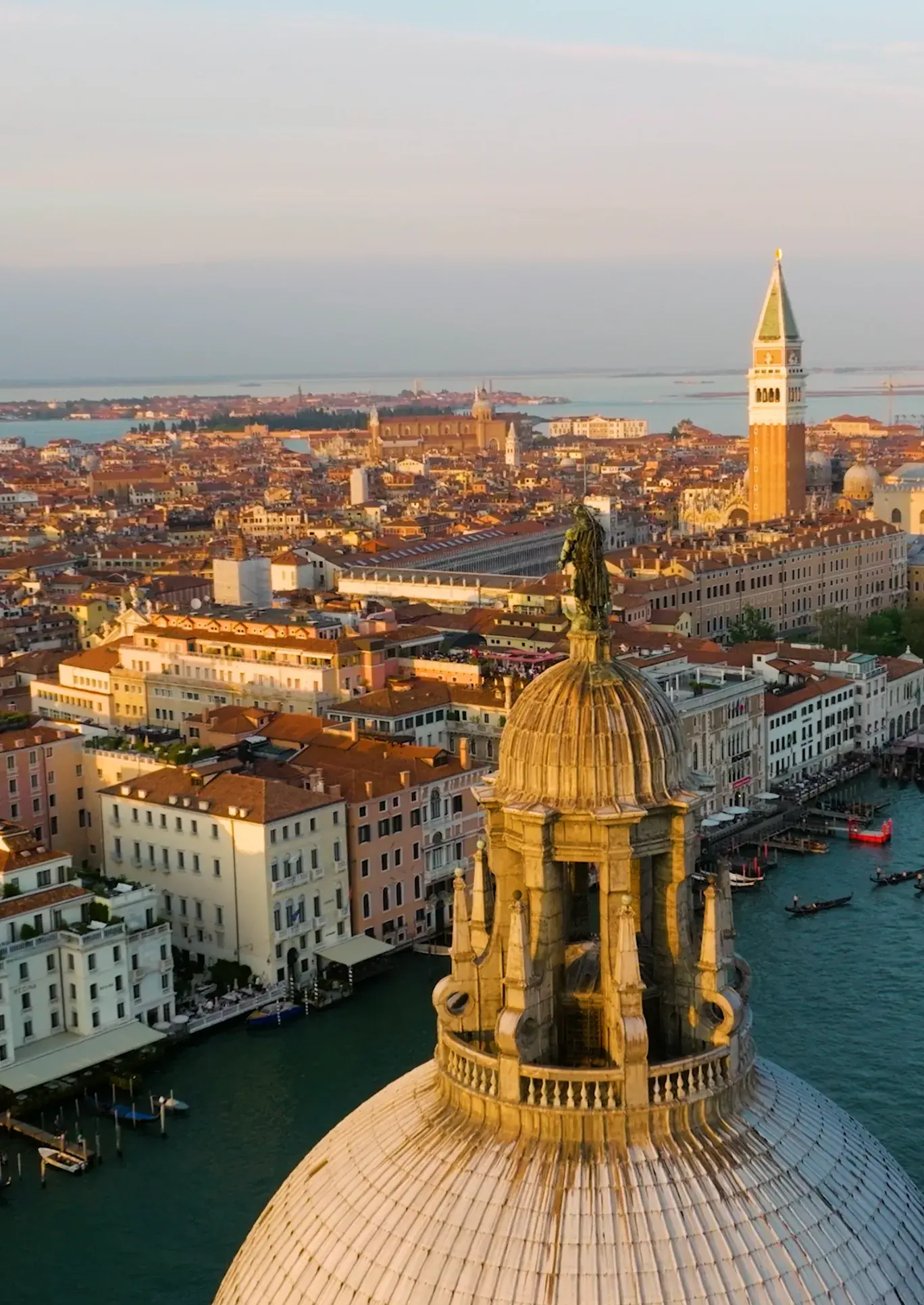 Aerial view of Venice rooftops and church dome at sunset